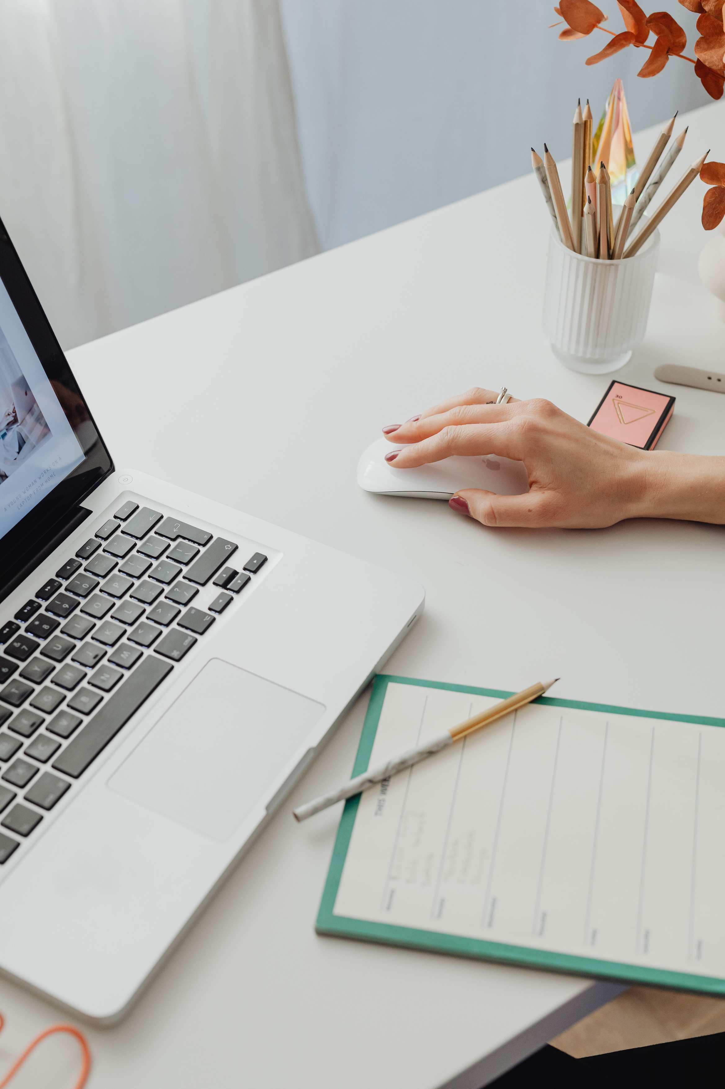 Hände arbeiten mit Papierbelegen und einem Laptop auf einem Schreibtisch